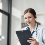 Imagem de uma profissional da área da saúde olhando o imposto de renda para médicos no tablet