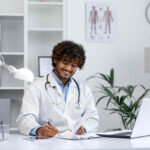 Médico sentado em seu escritório fazendo a emissão de atestado médico.